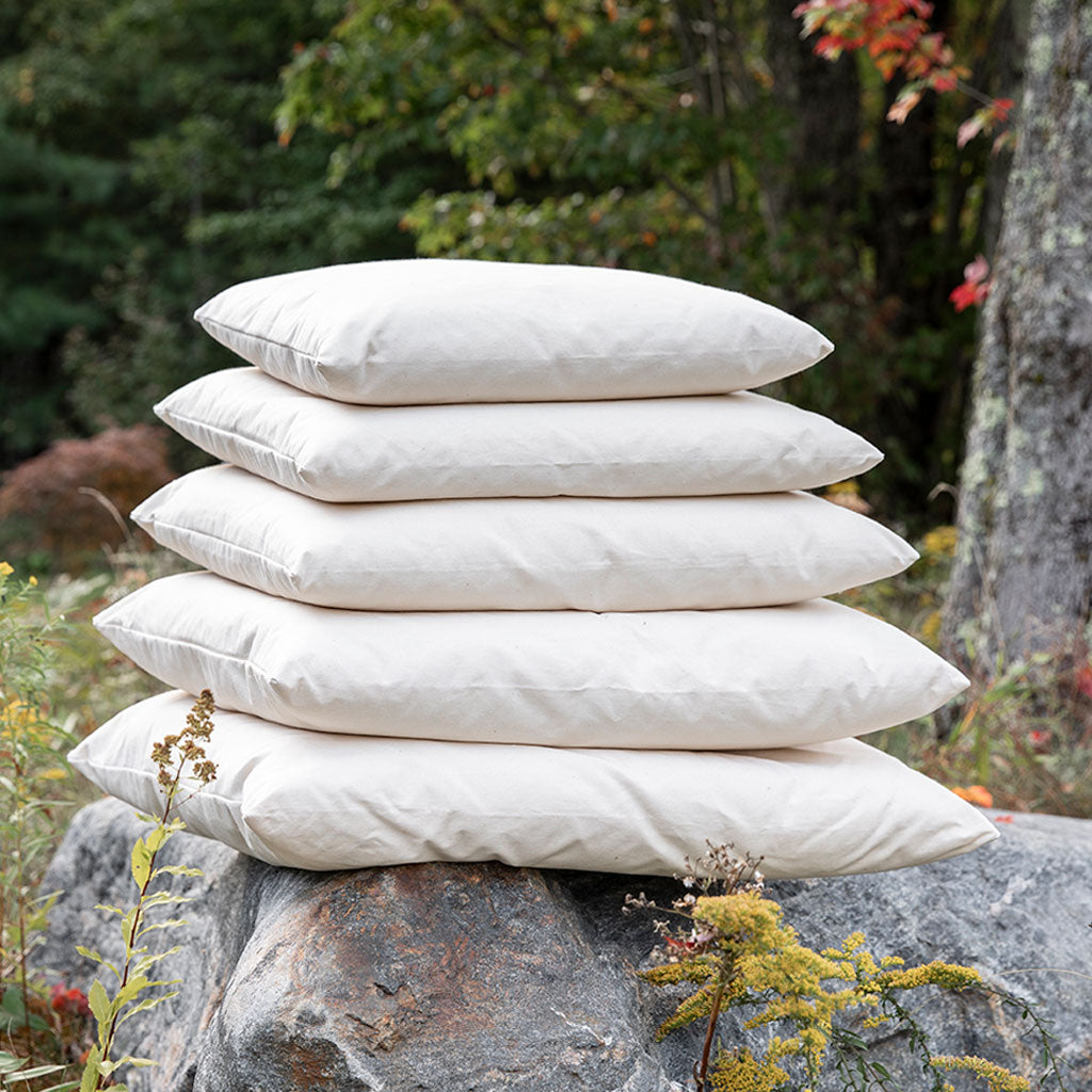 Five pillows stacked in an outdoor setting.