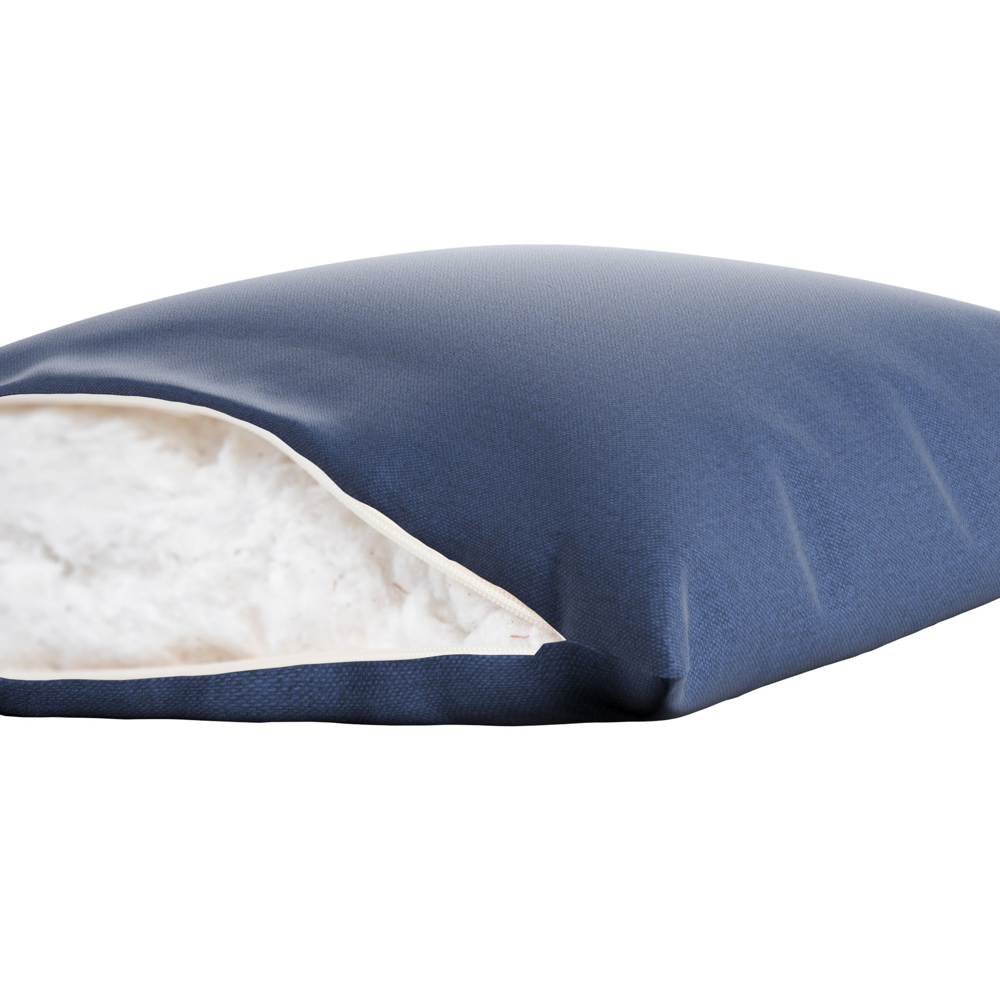 Denim blue pillow cover with zipper open showing cotton inside. On a white background.