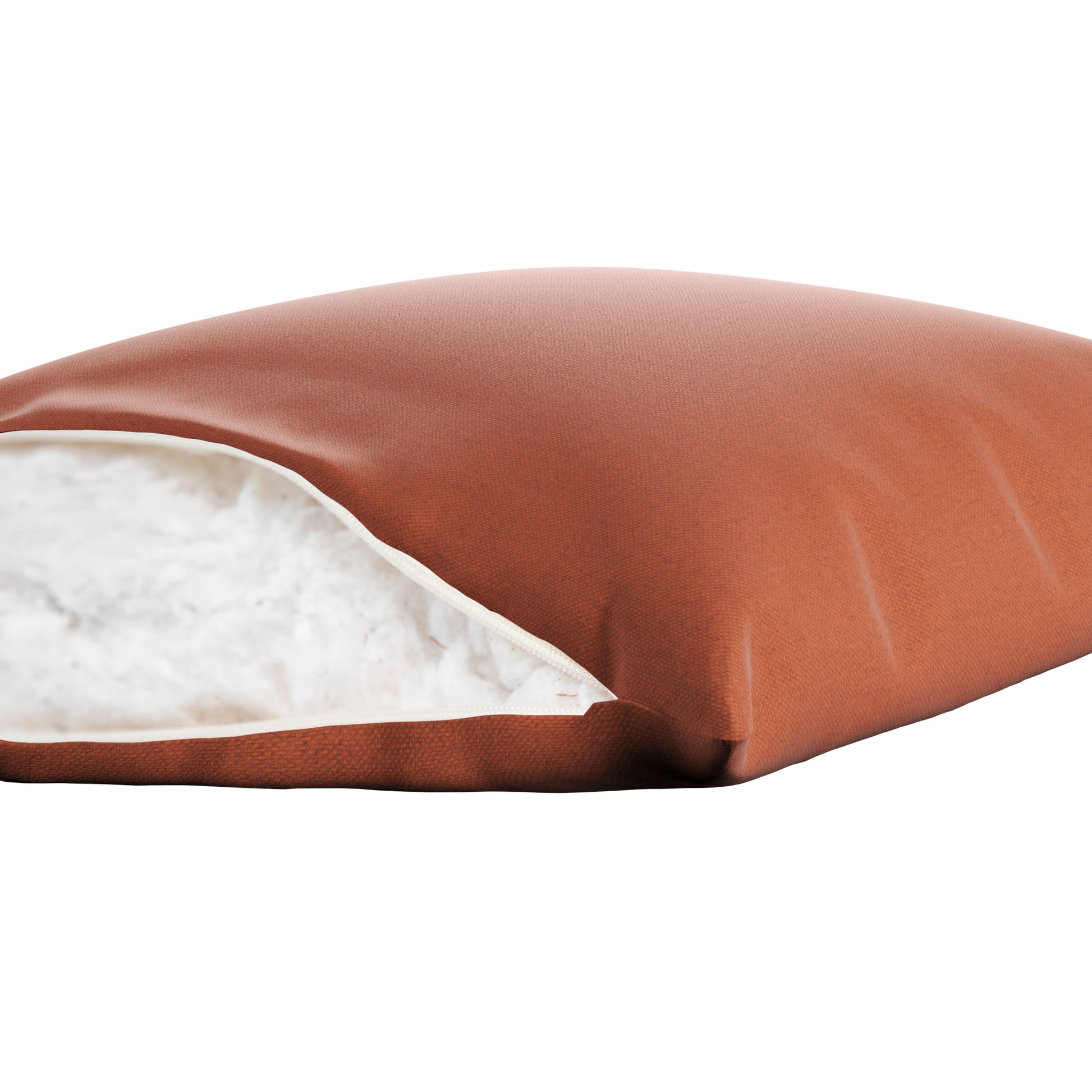 Burnt orange square pillow on a white background. Zipper open showing cotton inside.
